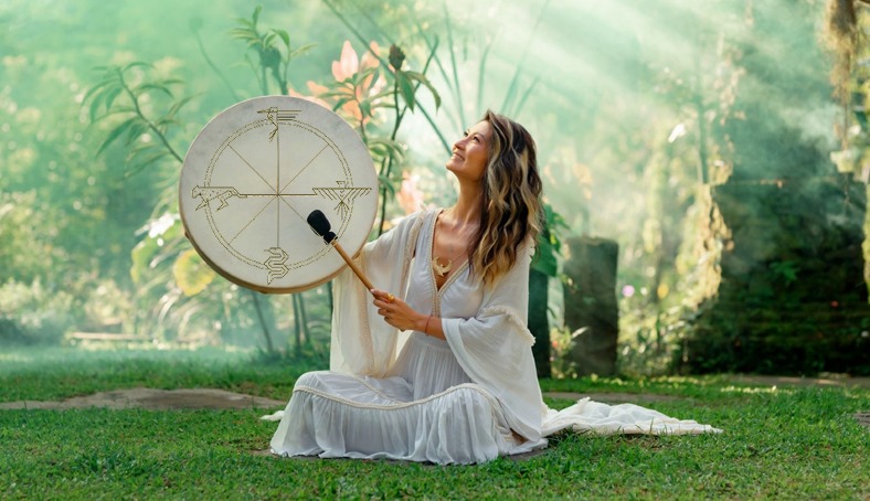 Nicole Yau seated with a ceremonial frame drum in the Bali jungle