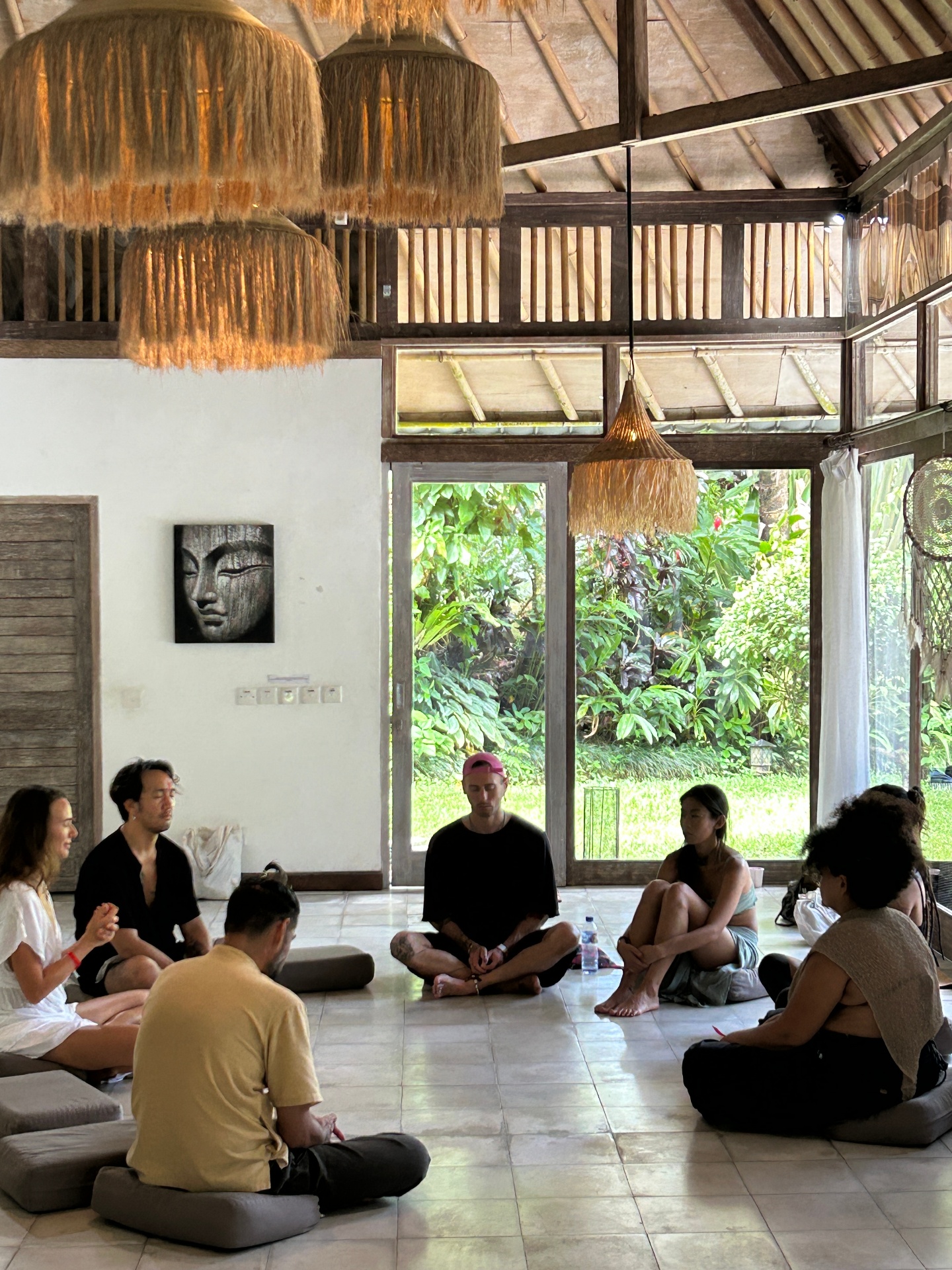 Participants seated together in a circle on cushions in the open hall at Samyama, beginning the workshop