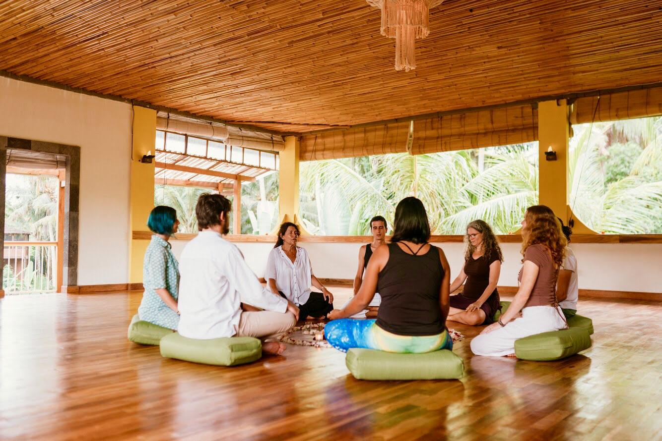 A small group seated together in Dhyana Hall, the held container of guided meditation and inquiry